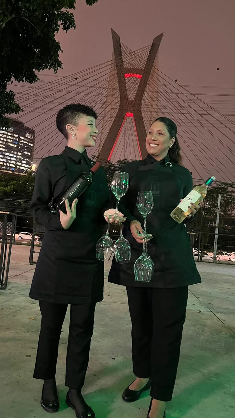Profissionais de bar da Aura Casting servindo vinho em evento noturno